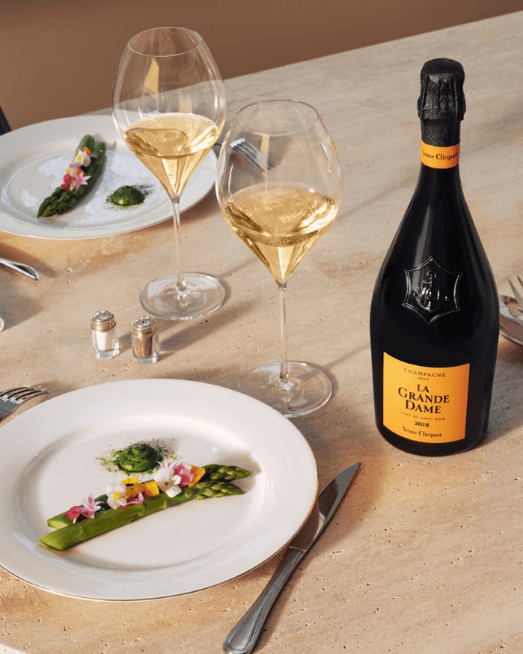 Bouteille de la Grande Dame 2018 avec deux verres en accord avec des asperges vertes blanchies