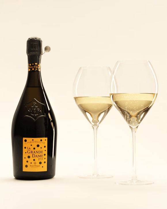 Bottle of La Grande Dame 2012 next to two glasses Bottle of La Grande Dame 2012 next to two glasses