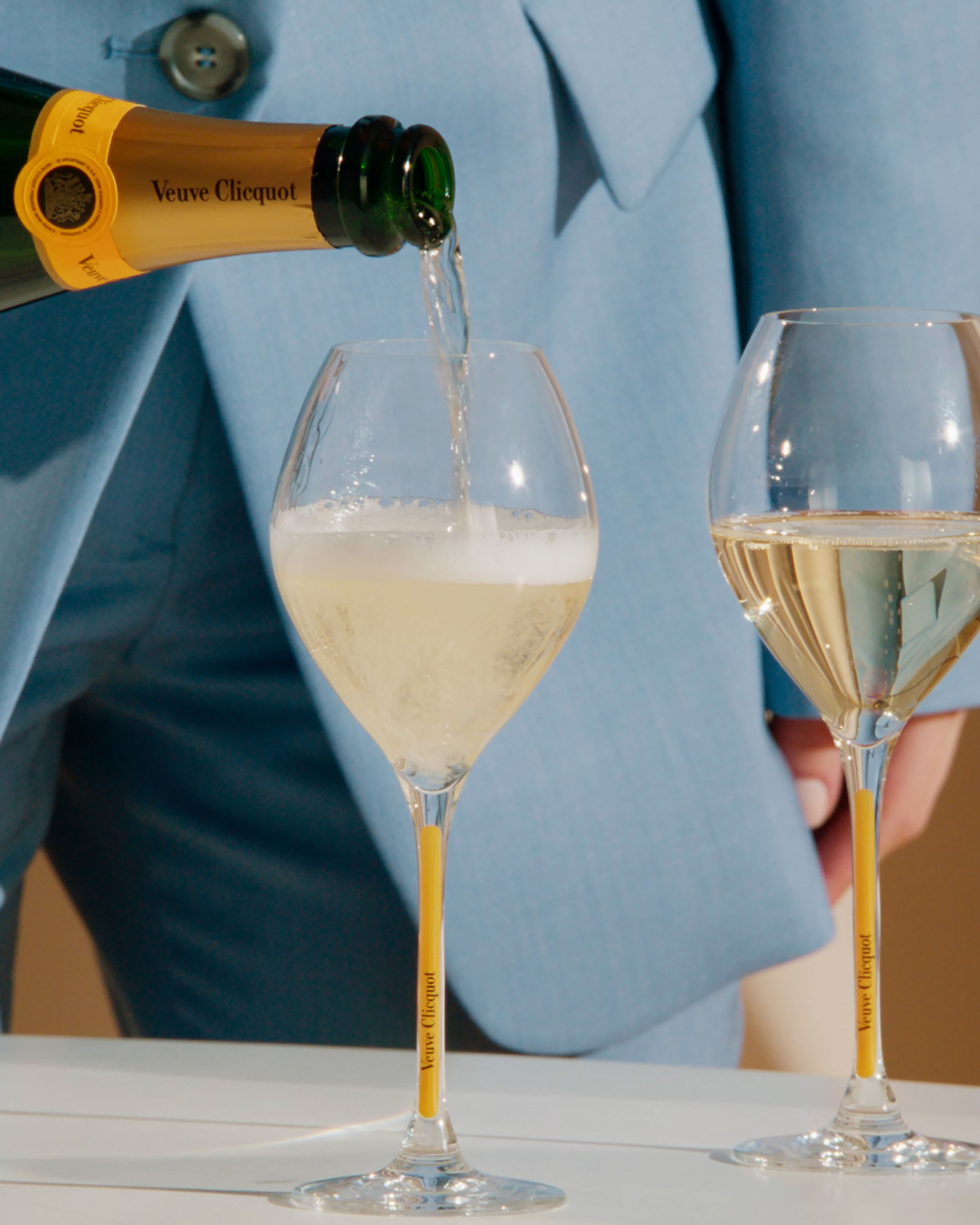 2 glasses of Veuve Clicquot champagne being poured