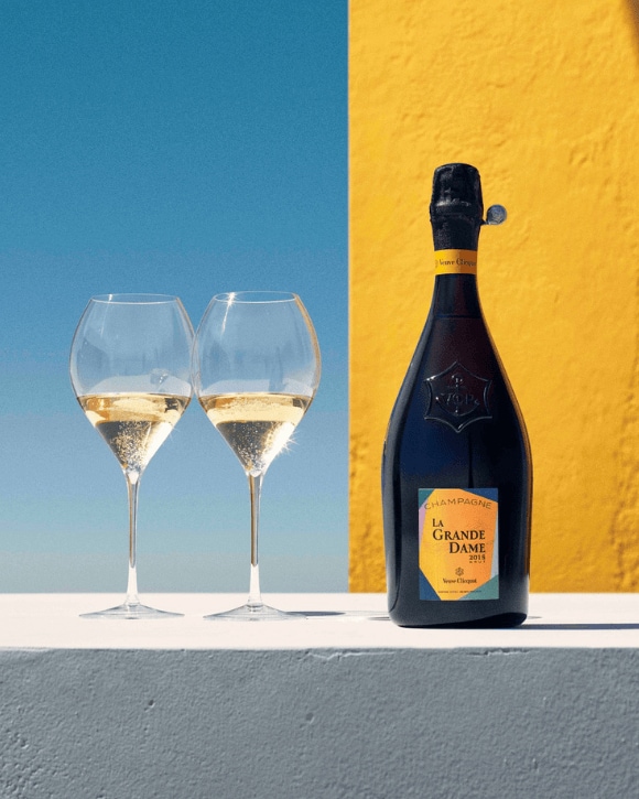 Bottle of La Grande Dame 2015 next to two glasses Bottle of La Grande Dame 2015 next to two glasses