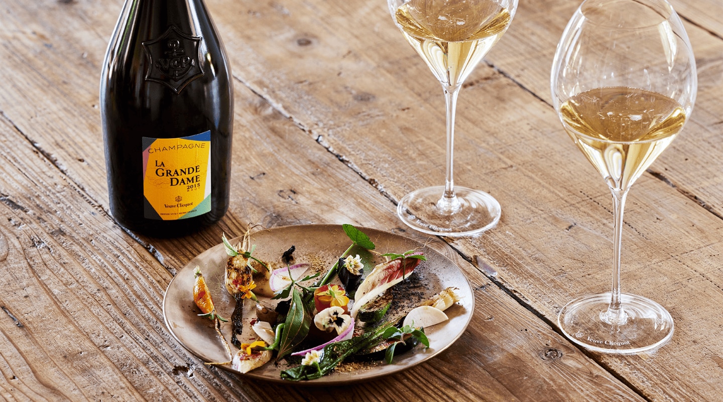 Un plat gastronomique, une bouteille de La Grande Dame 2015 et deux coupes de champagne Un plat gastronomique, une bouteille de La Grande Dame 2015 et deux coupes de champagne