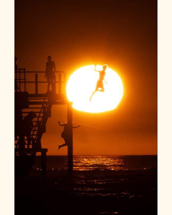 Trent Parke photo of a man jumping in the sea in front of a sunset Trent Parke photo of a man jumping in the sea in front of a sunset