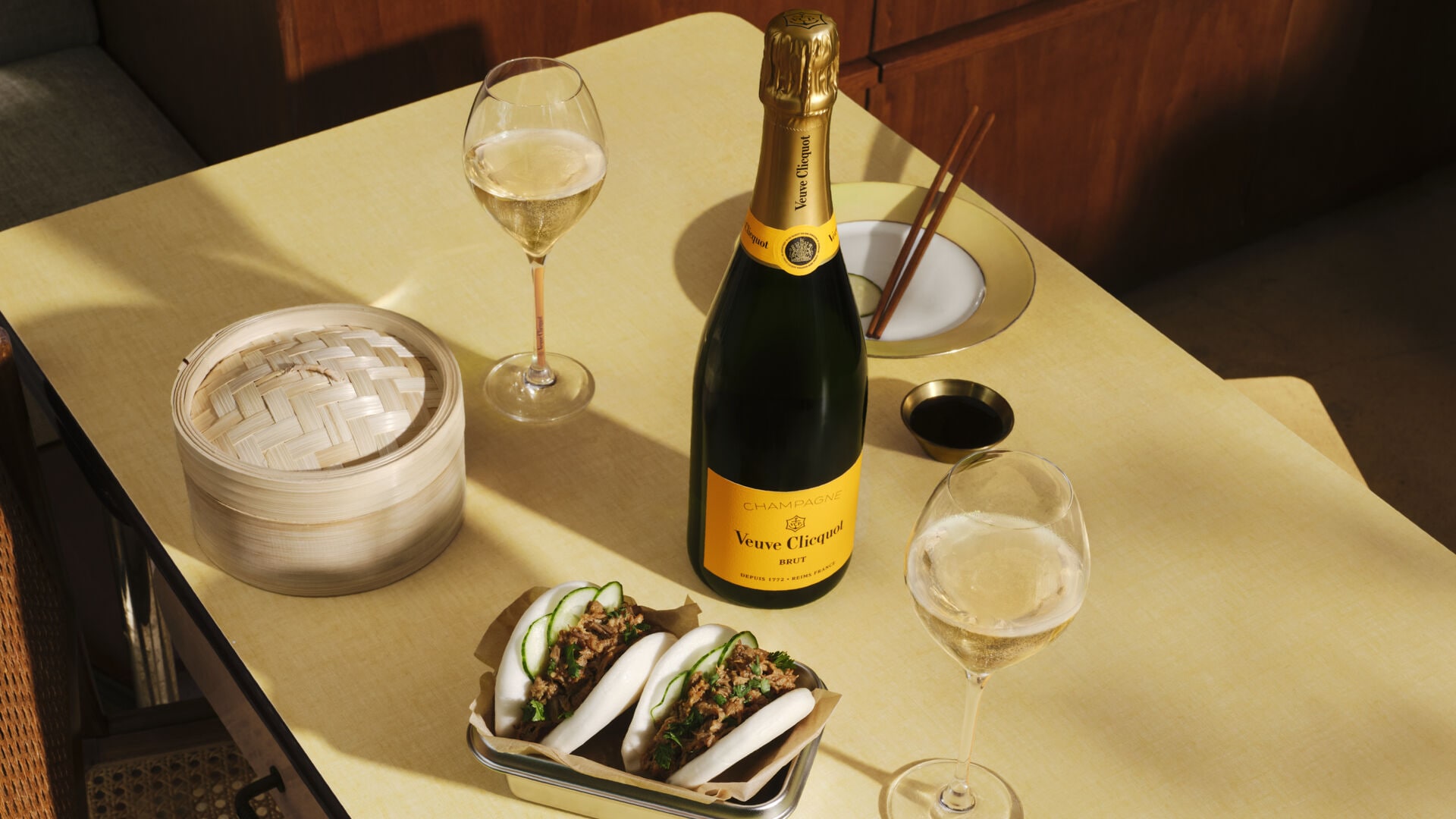 Veuve Clicquot yellow label bottle and 2 glasses of champagne seved with Bao buns