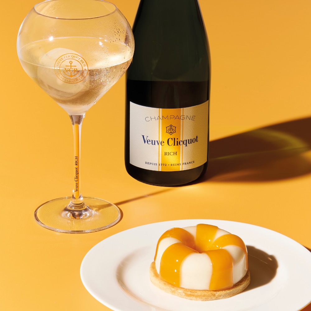 Bouteille de champagne RICH avec une coupe et un dessert