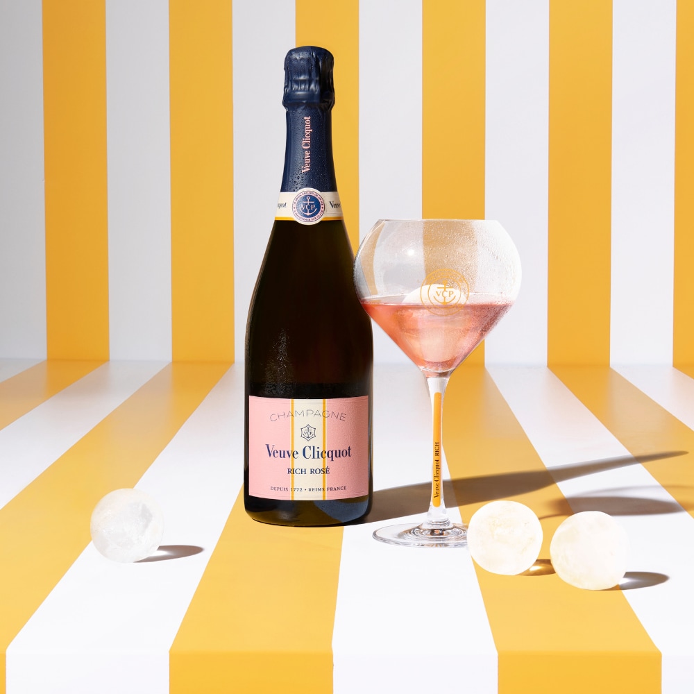 Bouteille de champagne RICH Rosé avec une coupe pleine et des glaçons sphériques