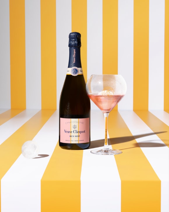 Bottle of RICH Rosé champagne with a glass and ice sphere